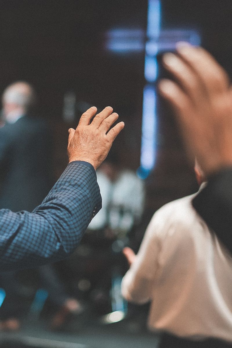 Hands raised toward a cross